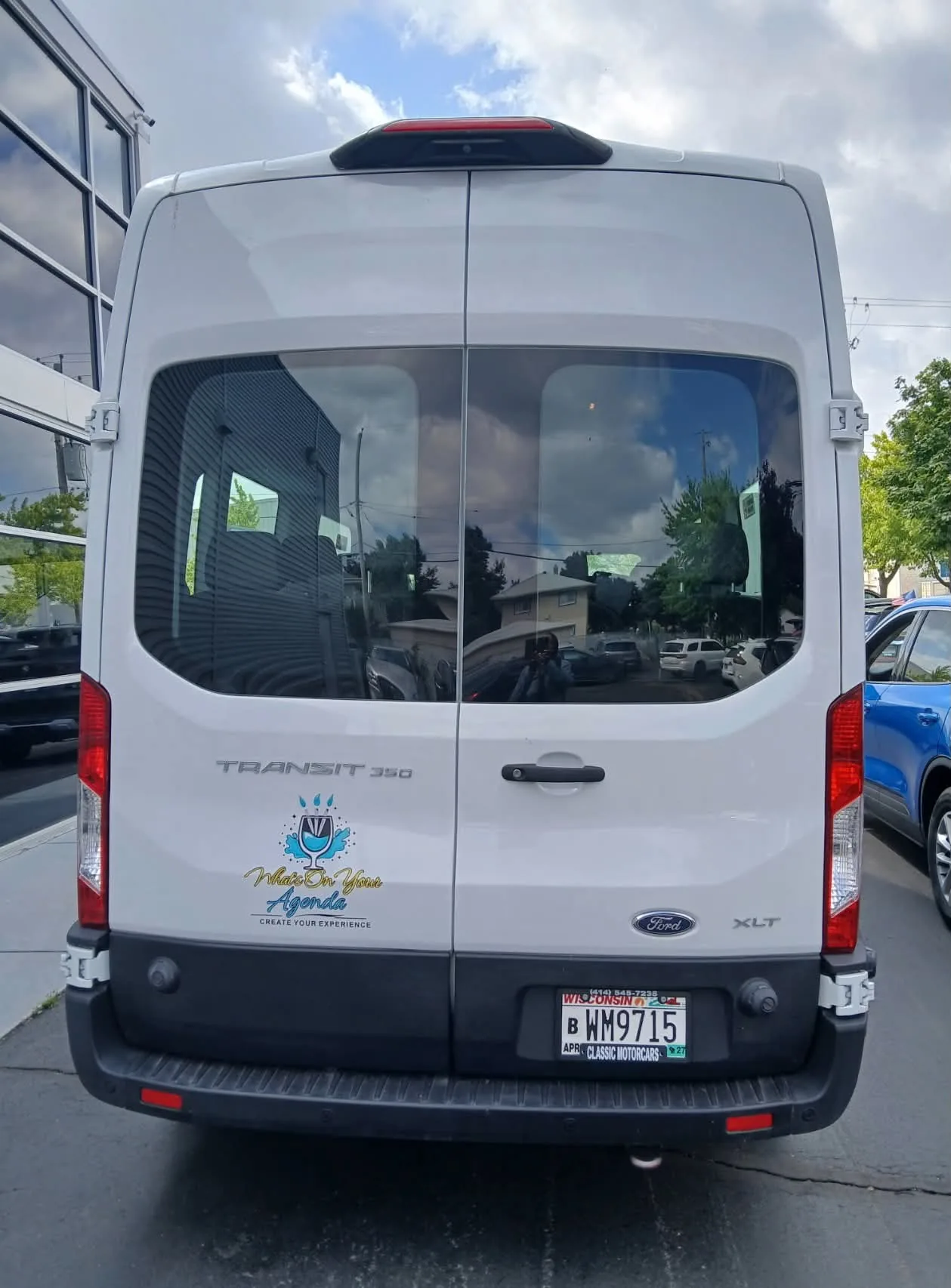 Rear of the What's On Your Agenda passenger van showing the company logo.